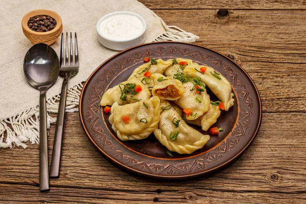 饺子塞满了炖菜和酸奶油 传统的乌克兰语菜 健康素食 老式木桌 — 图库照片