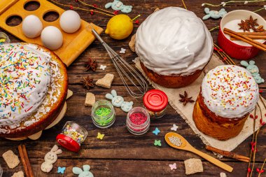 Paskalya pastası süslemesi. Şekerli, soslu, yenilebilir boncuklar. Doğal sağlıklı malzemeler, eski ahşap masa.