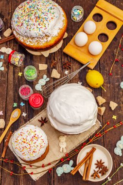 Paskalya pastası süslemesi. Şekerli, soslu, yenilebilir boncuklar. Doğal sağlıklı malzemeler, eski ahşap masa.