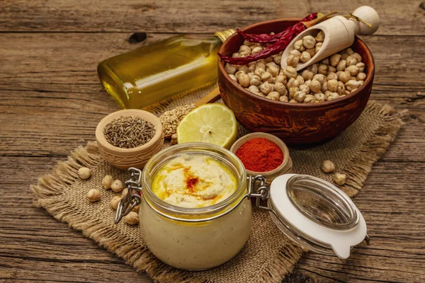 Eski tahta arka planda humus. Kuru nohut, zeytinyağı, limon, kimyon ve biber. Orta Doğu ve Akdeniz mutfağında geleneksel yiyecekler, yakın çekim