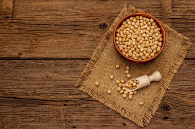 Eski tahta arka planda seramik kasede kuru nohut. Humus pişirmek için geleneksel malzeme. Orta Doğu ve Akdeniz mutfağı