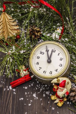 Gece yarısına beş dakika var. Yeni yıl konsepti. Çalar saat, çam dalı, Noel süslemeleri. Kara tahta arkaplanı