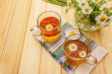 Papatya çayı. Taze çiçekler, yaz sıcak içecek konsepti. Alternatif tıp, yaşam tarzı. Tahta kaplama arka plan, kopyalama alanı.