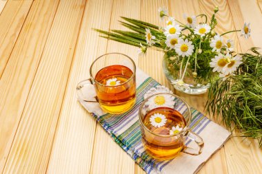Papatya çayı. Taze çiçekler, yaz sıcak içecek konsepti. Alternatif tıp, yaşam tarzı. Tahta kaplama arka plan, kopyalama alanı.
