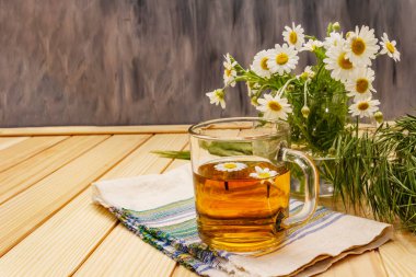 Papatya çayı. Taze çiçekler, yaz sıcak içecek konsepti. Alternatif tıp, yaşam tarzı. Tahta kaplama arka plan, kopyalama alanı.