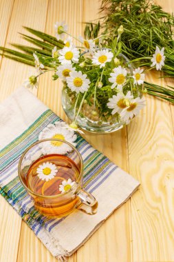 Papatya çayı. Taze çiçekler, yaz sıcak içecek konsepti. Alternatif tıp, yaşam tarzı. Tahta kaplama arka plan, kopyalama alanı.