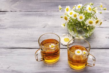 Papatya çayı. Taze çiçekler, yaz sıcak içecek konsepti. Alternatif tıp, yaşam tarzı. Tahta kaplama arka plan, kopyalama alanı.