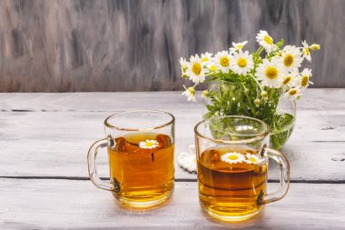 Papatya çayı. Taze çiçekler, yaz sıcak içecek konsepti. Alternatif tıp, yaşam tarzı. Tahta kaplama arka plan, kopyalama alanı.