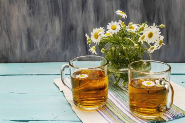 Papatya çayı. Taze çiçekler, yaz sıcak içecek konsepti. Alternatif tıp, yaşam tarzı. Moda turkuaz tahta tahta arka plan, kopyalama alanı