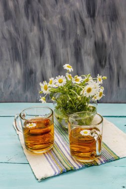 Papatya çayı. Taze çiçekler, yaz sıcak içecek konsepti. Alternatif tıp, yaşam tarzı. Moda turkuaz tahta tahta arka plan, kopyalama alanı