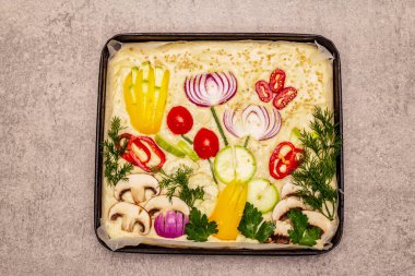 Raw Garden Focaccia 'da. Taze hamurlar, sebzeler, zeytinyağı, yeşiller. Renkli bahçe, taş beton zemin
