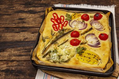 Renkli bahçe Focaccia 'sı. Taze sebzeler, zeytinyağı, yeşiller. Geleneksel İtalyan pastanesi. Eski tahta arka plan