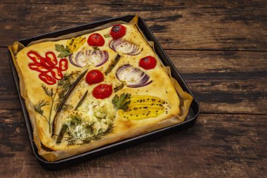 Renkli bahçe Focaccia 'sı. Taze sebzeler, zeytinyağı, yeşiller. Geleneksel İtalyan pastanesi. Eski tahta arka plan