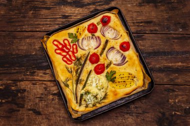 Renkli bahçe Focaccia 'sı. Taze sebzeler, zeytinyağı, yeşiller. Geleneksel İtalyan pastanesi. Eski tahta arka plan