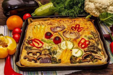 Renkli bahçe Focaccia 'sı. Taze sebzeler, zeytinyağı, yeşiller. Geleneksel İtalyan pastanesi. Eski tahta arka plan