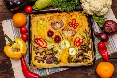 Renkli bahçe Focaccia 'sı. Taze sebzeler, zeytinyağı, yeşiller. Geleneksel İtalyan pastanesi. Eski tahta arka plan