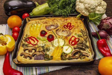 Renkli bahçe Focaccia 'sı. Taze sebzeler, zeytinyağı, yeşiller. Geleneksel İtalyan pastanesi. Eski tahta arka plan