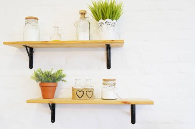 Beyaz tuğla duvar dokusunda ahşap raflar eski şişe ve çiçek vazolarıyla arka plan