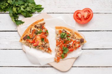 Yakın plan, beyaz ahşap arka planda peynirli iki dilim sıcak pizza..
