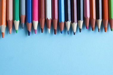 Mavi arka planda renkli kalemler yakın plan. Okula geri dön.