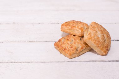 Tahta arka planda susamlı üç kurabiye ve bir kopya alanı