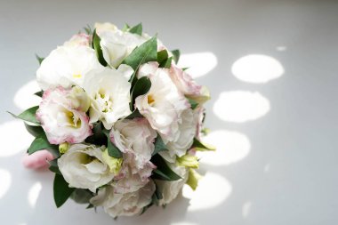 Gri arkaplanda hafif daireli gelin buketi.