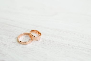 Alyanslar beyaz ahşap arka planda ve fotokopi alanı var. Aşk ve evlilik kavramı