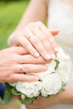 Düğün çifti. Gelin buketinde eller ve yüzükler var. Aşk ilanı. Düğün geçmişi, gün detayları