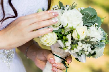 Gelinin buketi, gelin gelinlik içinde bir buket tutuyor..