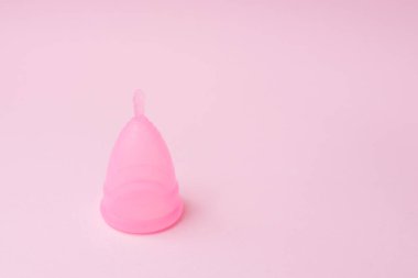 Pembe arka planda regl fincanı. Adet zamanı. Hijyen ve koruma. Boşluğu kopyala