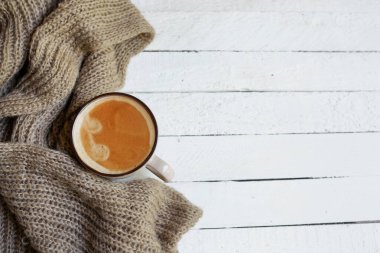 Beyaz ahşap arka planda eşarplı kahve flatlay, sonbahar veya kış konsepti