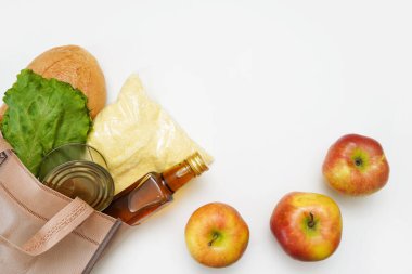 Beyaz arka planda birçok sağlıklı ürün içeren alışveriş torbası, kopyalama alanı