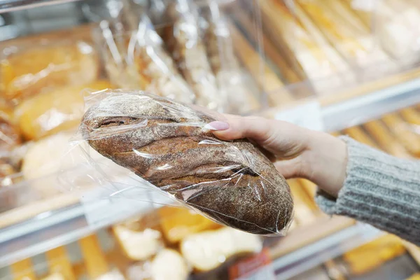Крупный план женщины, держащей хлеб на рынке — стоковое фото
