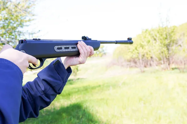 The man Shooting from a gun. Training shooting from an air rifle in the autumn afternoon