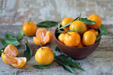 Seçici odaklanma. Bir kasede olgun, sulu mandalinalar. Mandalina yaprakları. Taze kokulu mandalinalar. Mandalina hasatı.