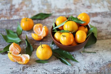 Seçici odaklanma. Bir kasede olgun, sulu mandalinalar. Mandalina yaprakları. Taze kokulu mandalinalar. Mandalina hasatı.