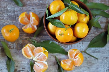 Seçici odaklanma. Bir kasede olgun, sulu mandalinalar. Mandalina yaprakları. Taze kokulu mandalinalar. Mandalina hasatı.