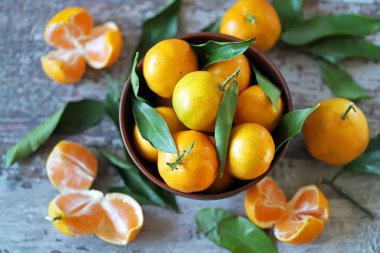 Seçici odaklanma. Bir kasede olgun, sulu mandalinalar. Mandalina yaprakları. Taze kokulu mandalinalar. Mandalina hasatı.