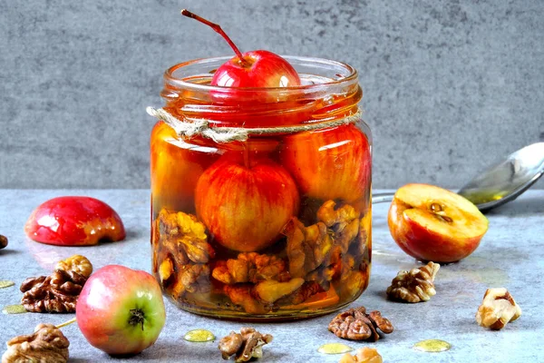 Paradise elma ve ceviz bal. Bir kavanoz bal küçük elma ve fındık ile. Besleyici bal karışımı kavanozun içinde. Tatlım, elma ve fındık vitamin karışımı.