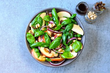 Fesleğen ve elmalı sağlıklı salata. Elmalı salata, kuru üzüm ve fındık. Elma fesleğenli vejetaryen bwl ve mavi soğan. Elma salatası. Elmalı, kuru üzümlü ve fıstıklı sonbahar salatası.