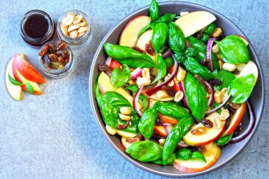 Fesleğen ve elmalı sağlıklı salata. Elmalı salata, kuru üzüm ve fındık. Elma fesleğenli vejetaryen bwl ve mavi soğan. Elma salatası. Elmalı, kuru üzümlü ve fıstıklı sonbahar salatası.