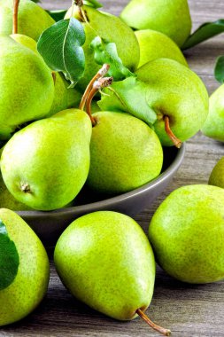 Bir kasede taze yeşil armutlar. Armut hasadı.