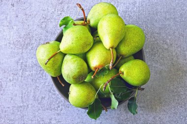 Bir kasede taze yeşil armutlar. Armut hasadı.