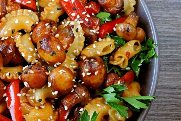 Pasta with mushrooms. Vegetarian dinner. Freshly prepared pasta with champignons. Delicious and healthy food in a bowl.