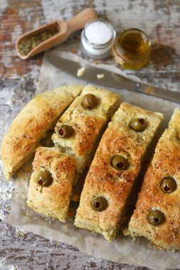 Seçici odaklanma. Makro. İtalyan otlu taze ev yapımı Focaccia. Evde yemek pişirmek. Zeytinli geleneksel İtalyan ekmeği..