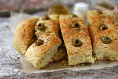 Seçici odaklanma. Makro. İtalyan otlu taze ev yapımı Focaccia. Evde yemek pişirmek. Zeytinli geleneksel İtalyan ekmeği..