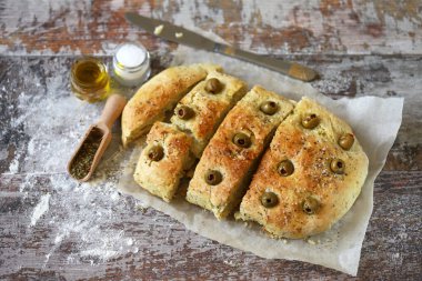 Seçici odaklanma. Makro. İtalyan otlu taze ev yapımı Focaccia. Evde yemek pişirmek. Zeytinli geleneksel İtalyan ekmeği..
