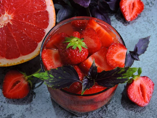 Refreshing detox drink for weight loss with strawberries, grapefruit and blue basil. Coecept of delicious and healthy food. Detox products for an ideal figure.