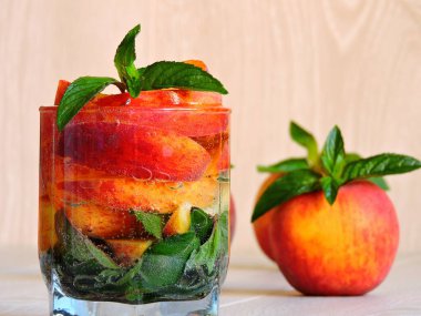 Nane ve şeftalili detoks içeceği. Hafif ahşap zemin. Boşluğu kopyala.