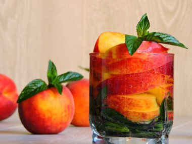 Nane ve şeftalili detoks içeceği. Hafif ahşap zemin. Boşluğu kopyala.